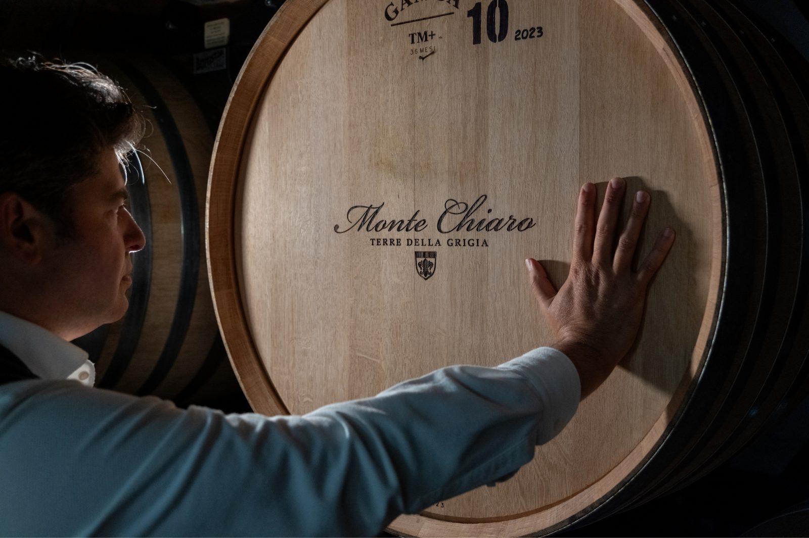 A hand on a 500-litre French oak tonneau in the Montechiaro cellar